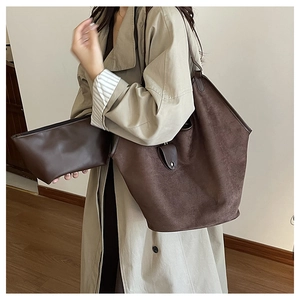Détail d'un ensemble cabas vintage en cuir marron avec sa pochette zippée assortie