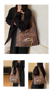 Detail of leopard print tote bag featuring branded logo and yellow braided zipper tassel