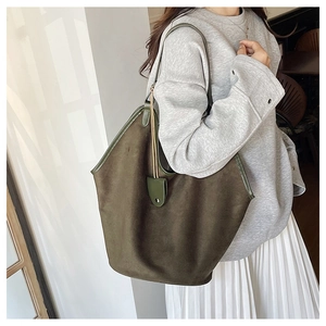 Detailed texture of green suede tote bag showing premium matte finish and leather trim