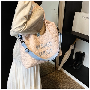 Détail du sac cabas matelassé rose avec broderie, montrant la texture nylon et les anses