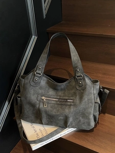 Grand sac fourre-tout vintage gris foncé avec bandoulière sur un support en bois rustique