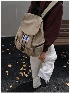 Détail d'un sac à dos en nylon kaki avec cordon de serrage et écusson dans un parc d'automne
