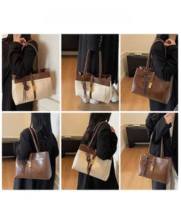 Détail d'un grand sac cabas avec pendentif tressé en couleurs beige et marron