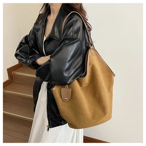 Close-up of large brown suede tote bag featuring high-quality matte texture and metal buckle