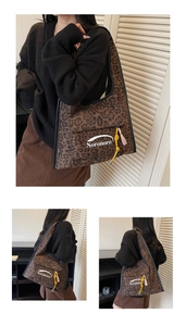 Detail of leopard print tote bag with white logo pocket and yellow braided rope trim