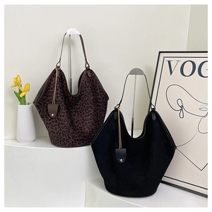 Retro large-capacity hobo bags in leopard print and black suede on a white display