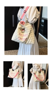 Détail du sac cabas matelassé avec broderie rose et large bandoulière confortable