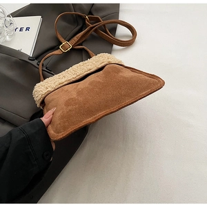 Close-up of brown suede crossbody bag with cream shearling trim and adjustable strap
