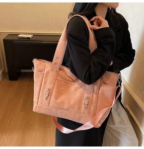 Detailed view of dusty pink tote bag with retro leather texture and adjustable strap