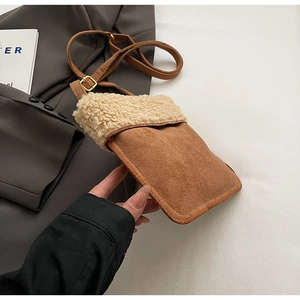 Detail of suede crossbody bag with sherpa trim and adjustable leather shoulder strap