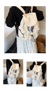 Détail du sac à dos crème avec fermeture à cordon et bretelles contrastées en noir et blanc