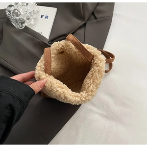 Detail view of mini plush bucket bag with brown suede finish and white faux fur trim