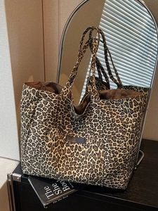 Large leopard print canvas tote bag with front pocket and sturdy handles in lifestyle setting