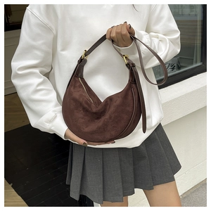 Nahaufnahme der braunen Wildleder-Hobo-Tasche mit Lederbesatz und Goldbeschlägen