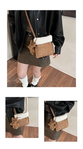 Brown suede crossbody bag with plush trim and cute bear charm shown on a model