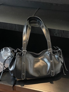 Glossy black hobo shoulder bag with pleated details and silver metal grommet straps