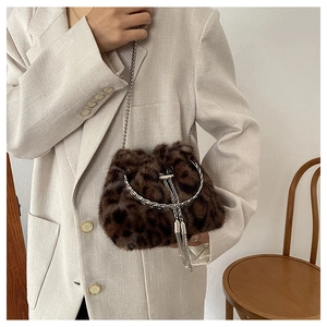 Détail du sac seau peluche léopard avec poignée anneau argenté et gland métallique