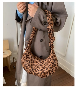Detail of leopard print crescent bag featuring unique ruched cloud handle design