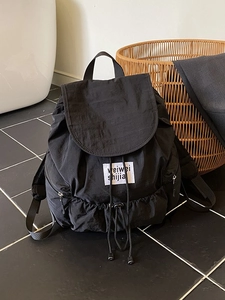 Sac à dos à cordon noir minimaliste en nylon imperméable avec étiquette tissée blanche