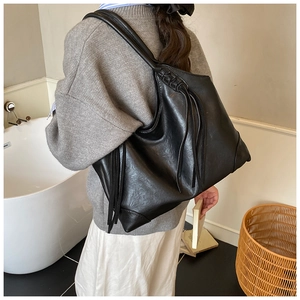 Gros plan d'un grand sac cabas noir en cuir mat avec de longs détails de franges stylés