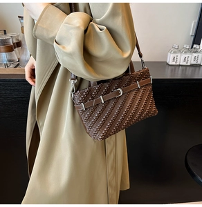 Close-up of pleated texture and silver buckle on dark brown retro Boston handbag
