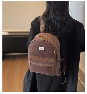 Détail d'un sac à dos imprimé léopard avec fermeture dorée et fini en daim texturé