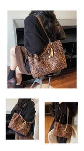 Detail of leopard print tote bag featuring brown leather straps and beaded ornament