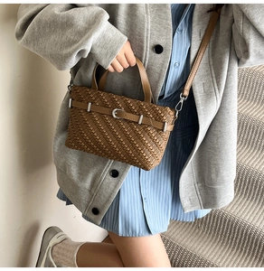 Brown Boston bag with woven texture and silver buckle shown in a lifestyle setting