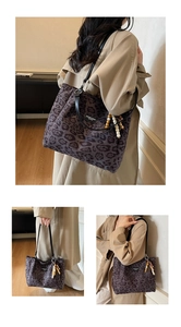 Detail of purple leopard tote bag with wood bead tassel and black leather handles