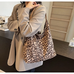 Hobo leopard print canvas shoulder bag styled in a cozy cafe interior setting