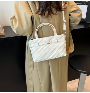 Detailed view of a white pleated Boston bag with silver hardware and textured finish