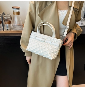 Detailed close-up of a white pleated texture shoulder bag with metallic buckle detail