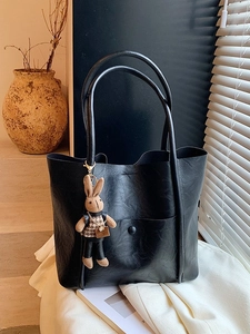 Large black leather tote bag with rabbit charm and front pocket for commute