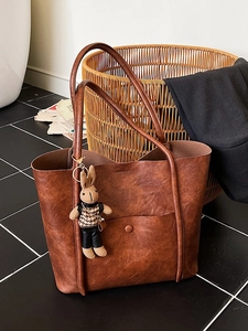 Brown vintage wax leather tote bag with rabbit charm and minimalist retro buckle