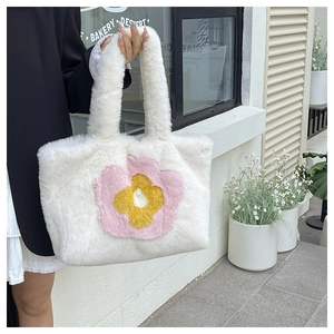 Detailaufnahme der weichen Plüschtasche mit Sonnenblumenmuster in Rosa und Gelb