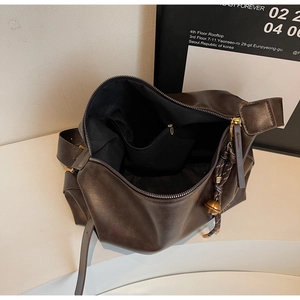 Détail du sac cabas marron foncé en similicuir avec poche zippée et grelot doré