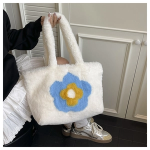 Detail der weißen Plüschtasche mit Sonnenblume, weicher Pelztextur und großem Design