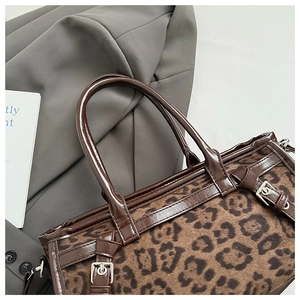 Vue détaillée du sac cabas léopard avec anses en cuir marron et boucles argentées