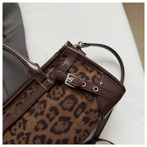 Détail du daim à imprimé léopard et texture cuir avec boucle métallique argentée