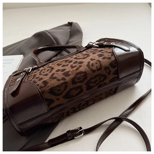 Détail du sac cylindre léopard avec similicuir marron et boucles métalliques argentées