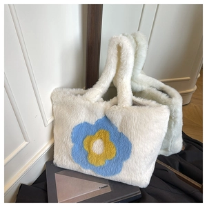 Detailansicht der cremefarbenen Plüschtasche mit blau-gelber Sonnenblumen-Stickerei