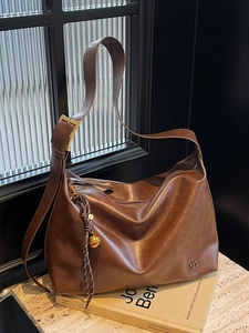 Grand sac cabas rétro en cuir marron foncé avec boucle dorée sur socle en marbre