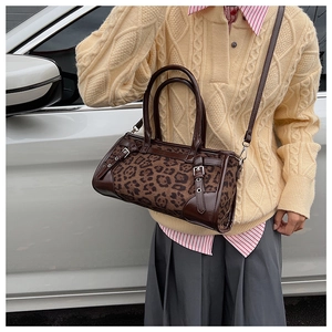 Détail du sac boston imprimé léopard avec finitions en cuir verni marron et boucles métal