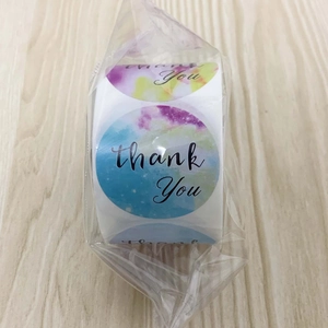 Détail d'autocollants Thank You en rouleau avec motif aquarelle sur fond bois clair