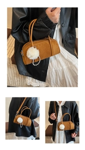 Detail of suede bowling bag featuring a soft white plush ball and pearl charm accessories