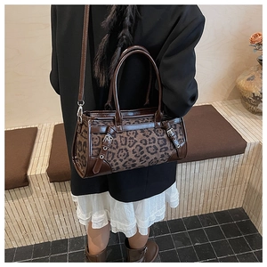Vue détaillée du sac Boston léopard avec bordures en cuir et bandoulière réglable