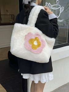 Weiße Plüsch-Tragetasche mit Blumenstickerei im Streetstyle-Außenbereich gezeigt
