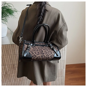Détail de textile imprimé léopard et cuir noir brillant avec des boucles métalliques chic