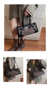 Détail du sac Boston imprimé léopard avec bordures en cuir noir et boucle métallique