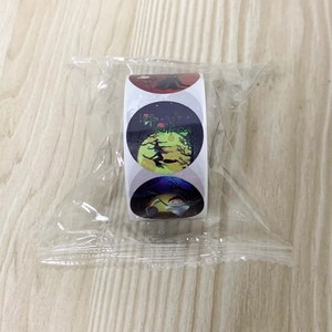 Close-up of Halloween cartoon round stickers roll including witches and pumpkins in plastic wrap
